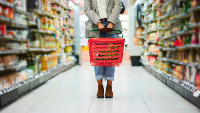 Supermarket aisle, woman legs and basket for shopping in grocery store. Customer, organic grocery shopping and healthy food on groceries sale shelf or eco friendly retail purchase in health shop